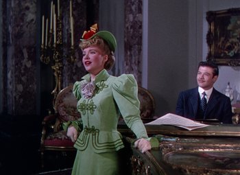 Movie still from “The Climax” (1944), directed by George Waggner – A woman wearing a green dress and a hat; Medium shot, Low angle