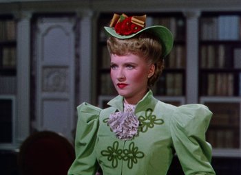 Movie still from “The Climax” (1944), directed by George Waggner – A woman wearing a green dress and a hat; Close Up shot, Low angle