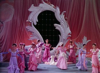 Movie still from “The Climax” (1944), directed by George Waggner – A group of women dressed in pink and purple gowns; Wide shot, Low angle