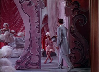 Movie still from “The Climax” (1944), directed by George Waggner – A man and a woman are standing next to each other in front of a mirror; Wide shot, Low angle