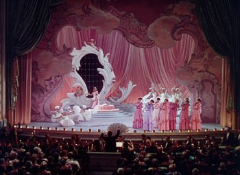 Movie still from “The Climax” (1944), directed by George Waggner – A large audience is sitting in front of a stage; Extreme Wide shot, High angle