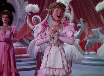 Movie still from “The Climax” (1944), directed by George Waggner – A group of women dressed in pink costumes; Medium shot, Low angle