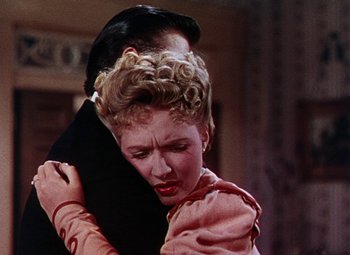 Movie still from “The Climax” (1944), directed by George Waggner – A man and a woman embracing each other in front of a wall; Close Up shot, Over the shoulder angle