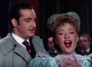 Movie still from “The Climax” (1944), directed by George Waggner – A man and a woman are standing next to each other; Close Up shot, Low angle