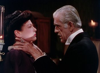 Movie still from “The Climax” (1944), directed by George Waggner – An older man and a younger woman in a black suit; Close Up shot, Over the shoulder angle