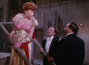 Movie still from “The Climax” (1944), directed by George Waggner – A man and two women standing next to each other; Medium shot, Low angle