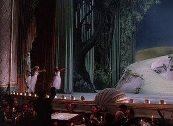 Movie still from “The Climax” (1944), directed by George Waggner – A scene of a stage with a bunch of people watching; Extreme Wide shot, Low angle