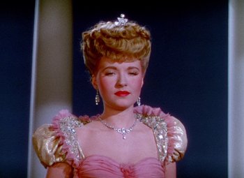 Movie still from “The Climax” (1944), directed by George Waggner – A woman in a pink dress and a tiara; Close Up shot, Low angle