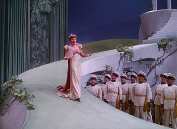 Movie still from “The Climax” (1944), directed by George Waggner – A group of people standing around a stage; Wide shot, High angle
