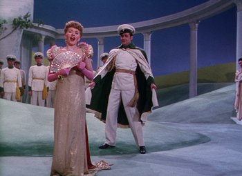Movie still from “The Climax” (1944), directed by George Waggner – A man and a woman are dressed in formal attire; Wide shot, Low angle
