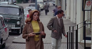 Movie still from “The Collector” (1965), directed by William Wyler – A woman in a yellow top and a man in a brown coat; Medium shot, Low angle