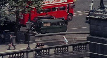 Movie still from “The Collector” (1965), directed by William Wyler – A double decker bus driving down a street; Wide shot, High angle