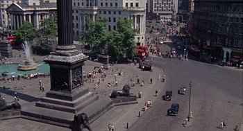 Movie still from “The Collector” (1965), directed by William Wyler – An aerial view of a busy city street with people walking around; Extreme Wide shot, High angle