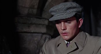Movie still from “The Collector” (1965), directed by William Wyler – A man wearing a hat and a trench coat; Close Up shot, High angle
