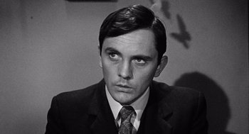 Movie still from “The Collector” (1965), directed by William Wyler – Black and white photograph of a man wearing a suit and tie; Close Up shot, High angle