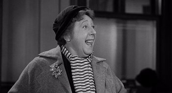 Movie still from “The Collector” (1965), directed by William Wyler – An older woman wearing a hat and a jacket; Close Up shot, Over the shoulder angle