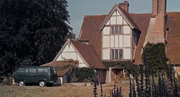 Movie still from “The Collector” (1965), directed by William Wyler – An old house with a van parked in front of it; Extreme Wide shot, Low angle
