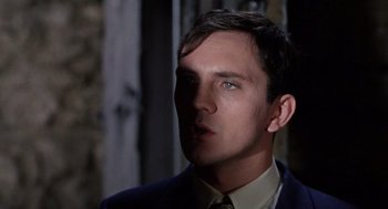 Movie still from “The Collector” (1965), directed by William Wyler – A man in a suit and tie looking to his left; Close Up shot, Low angle