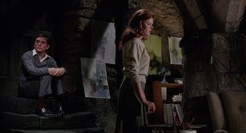 Movie still from “The Collector” (1965), directed by William Wyler – A woman standing in front of a wall in a room; Wide shot, Low angle