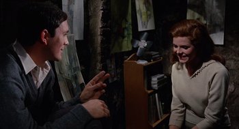 Movie still from “The Collector” (1965), directed by William Wyler – Two people are talking in a room with paintings on the walls; Medium shot, Over the shoulder angle