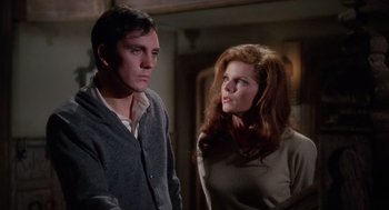 Movie still from “The Collector” (1965), directed by William Wyler – A man and a woman standing next to each other in a room; Medium shot, Low angle