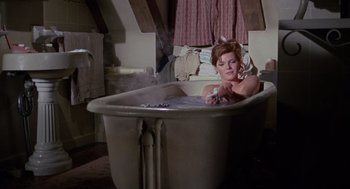 Movie still from “The Collector” (1965), directed by William Wyler – A woman sitting in a bath tub in a room; Medium shot, High angle
