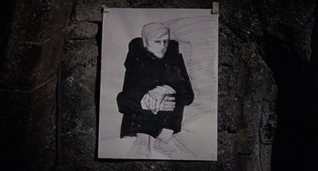 Movie still from “The Collector” (1965), directed by William Wyler – A black and white drawing of a person sitting on the ground; Close Up shot, High angle