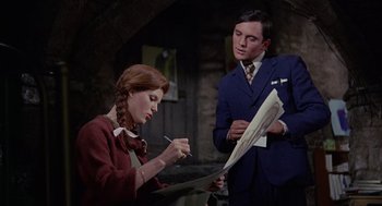 Movie still from “The Collector” (1965), directed by William Wyler – A man and a woman are looking at papers; Medium shot, Low angle