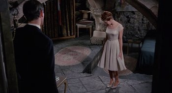 Movie still from “The Collector” (1965), directed by William Wyler – A woman in a white dress standing in front of a man; Wide shot, High angle