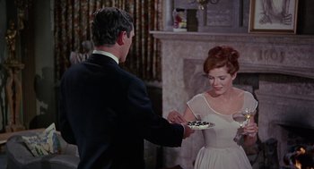 Movie still from “The Collector” (1965), directed by William Wyler – A man and a woman are holding a plate of food; Medium shot, High angle