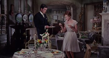 Movie still from “The Collector” (1965), directed by William Wyler – A man and a woman standing in front of a dinner table; Medium shot, High angle