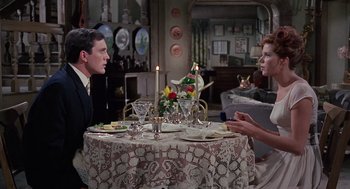 Movie still from “The Collector” (1965), directed by William Wyler – A man and a woman sitting at a dinner table; Medium shot, Over the shoulder angle