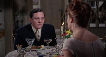 Movie still from “The Collector” (1965), directed by William Wyler – A man sitting at a dinner table looking at a woman; Close Up shot, Over the shoulder angle