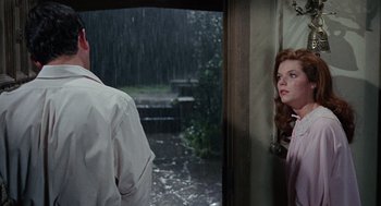 Movie still from “The Collector” (1965), directed by William Wyler – A man and a woman standing in front of a door; Medium shot, Over the shoulder angle