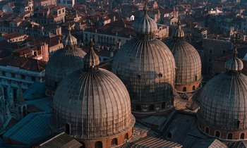 Movie still from “The Comfort of Strangers” (1990), directed by Paul Schrader – Three domed buildings in a large city; Extreme Wide shot, High angle