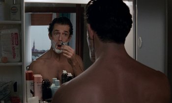 Movie still from “The Comfort of Strangers” (1990), directed by Paul Schrader – A man shaving in front of a bathroom mirror; Close Up shot, Over the shoulder angle