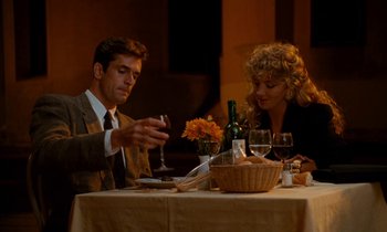 Movie still from “The Comfort of Strangers” (1990), directed by Paul Schrader – A man and a woman sitting at a dinner table; Medium shot, Low angle