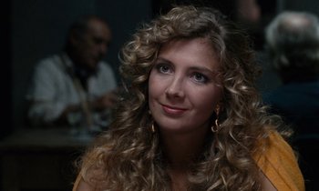 Movie still from “The Comfort of Strangers” (1990), directed by Paul Schrader – A beautiful woman with long curly blonde hair; Close Up shot, Over the shoulder angle