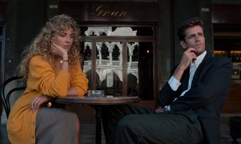 Movie still from “The Comfort of Strangers” (1990), directed by Paul Schrader – A man and a woman sitting in front of a table; Medium shot, Low angle