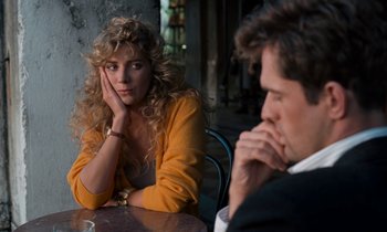 Movie still from “The Comfort of Strangers” (1990), directed by Paul Schrader – A woman sitting next to a man at a table; Close Up shot, Over the shoulder angle