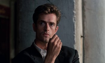 Movie still from “The Comfort of Strangers” (1990), directed by Paul Schrader – A man in a suit is posing for a picture; Close Up shot, Low angle