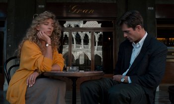 Movie still from “The Comfort of Strangers” (1990), directed by Paul Schrader – A man and a woman sitting in front of a table; Medium shot, Low angle