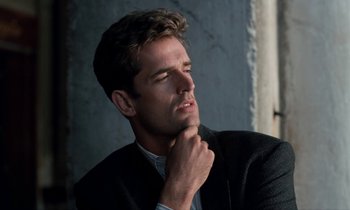 Movie still from “The Comfort of Strangers” (1990), directed by Paul Schrader – A man in a suit and tie with his hand under his chin; Close Up shot, Low angle