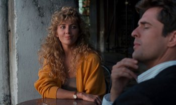 Movie still from “The Comfort of Strangers” (1990), directed by Paul Schrader – A woman sitting next to a man at a table; Close Up shot, Over the shoulder angle