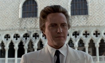 Movie still from “The Comfort of Strangers” (1990), directed by Paul Schrader – A person wearing a suit and tie; Close Up shot, Low angle