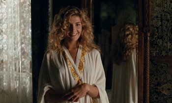 Movie still from “The Comfort of Strangers” (1990), directed by Paul Schrader – A woman in a white robe standing in front of a mirror; Medium shot, Over the shoulder angle