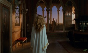 Movie still from “The Comfort of Strangers” (1990), directed by Paul Schrader – A woman standing in front of an open door; Wide shot, Over the shoulder angle