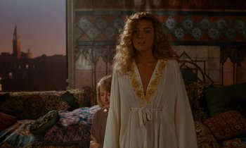 Movie still from “The Comfort of Strangers” (1990), directed by Paul Schrader – A woman standing next to a child in a living room; Medium shot, Over the shoulder angle
