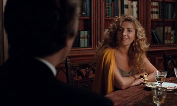 Movie still from “The Comfort of Strangers” (1990), directed by Paul Schrader – A woman sitting at a table in front of a man; Medium shot, Over the shoulder angle