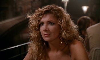 Movie still from “The Comfort of Strangers” (1990), directed by Paul Schrader – A beautiful woman with long blonde curly hair; Close Up shot, Over the shoulder angle